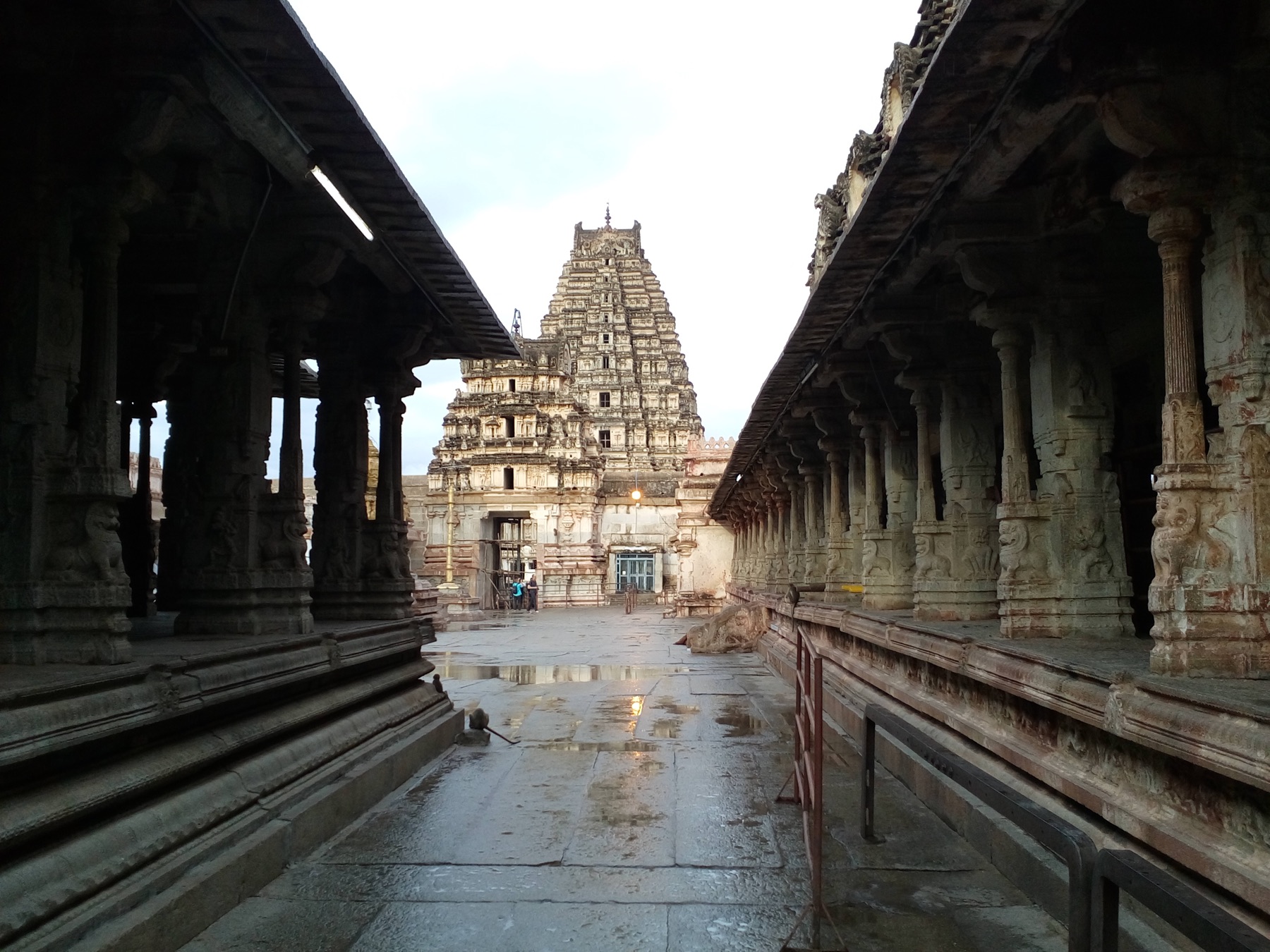 Virupaksha Temple tower framed by stone corridors in Hampi