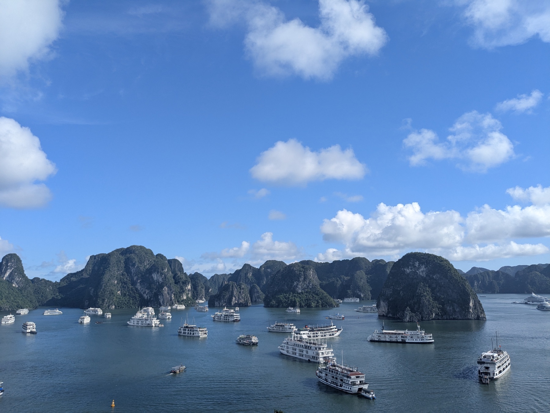 Boats scattered among limestone islands seen from a high overlook