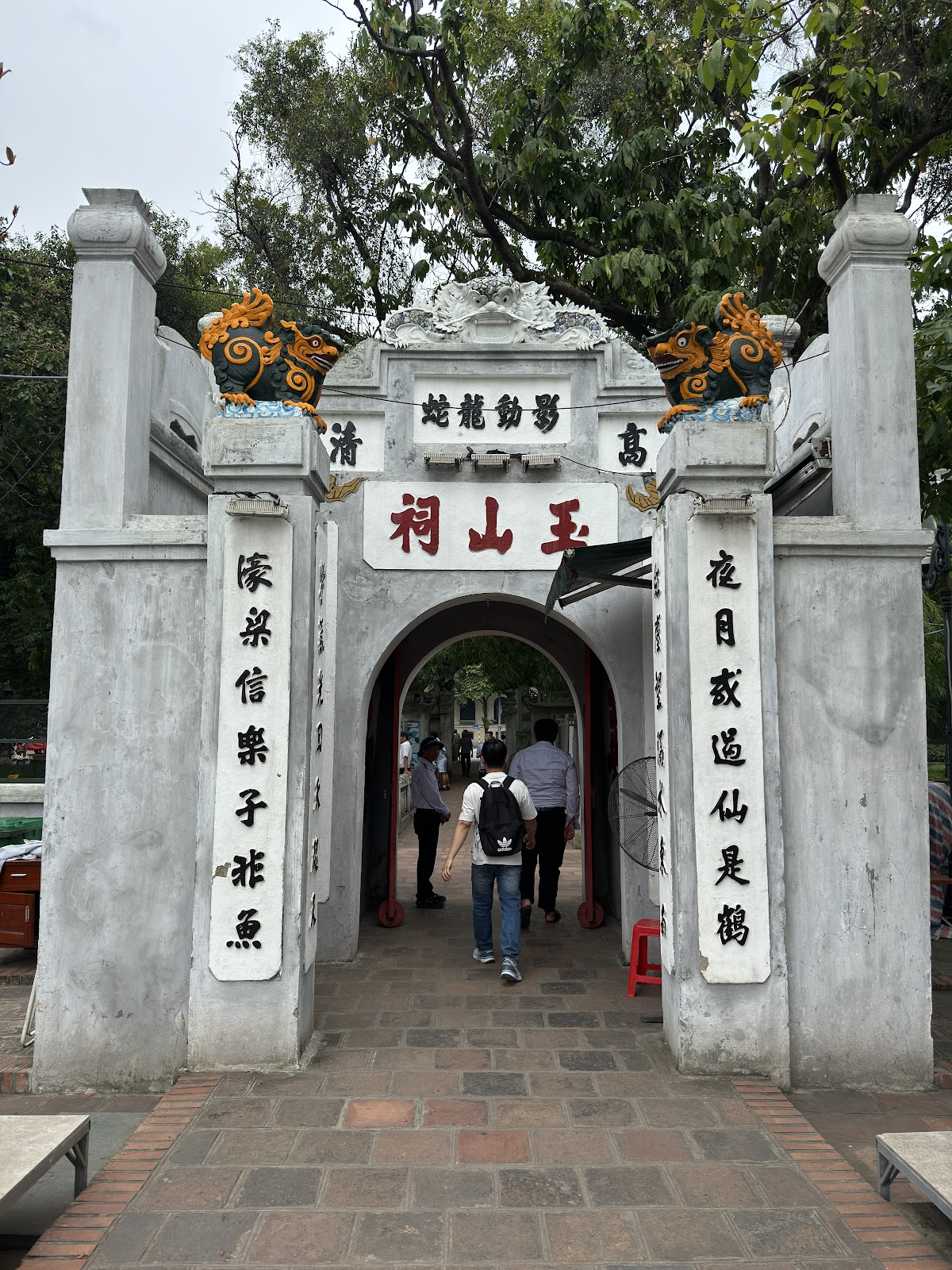 Stone gateway decorated with colourful creatures at Ngoc Son Temple